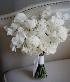 a bouquet of white flowers sitting on top of a couch