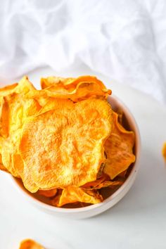 a bowl filled with potato chips on top of a white plate