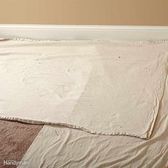 a blanket is laying on the floor in front of a wall with a brown and tan color scheme