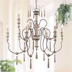 a chandelier hanging from the ceiling in a room with white walls and curtains