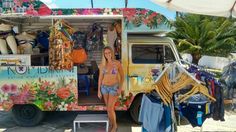 a woman standing in front of an ice cream truck with clothes hanging out to dry