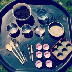 an outdoor table with bowls, spoons and measuring cups