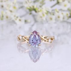 an engagement ring with a pink stone surrounded by white flowers