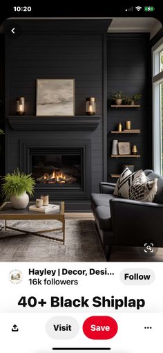 a living room filled with furniture and a fire place in front of a black wall