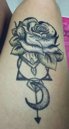 a tattoo on the thigh of a woman with a rose and letter s in it