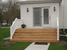 a house with white siding and wooden steps