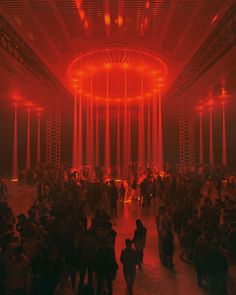 a large group of people standing around in a room with red lights on the ceiling