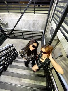 two young women are standing on the stairs