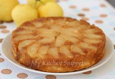 a cake sitting on top of a white plate next to some lemons and apples