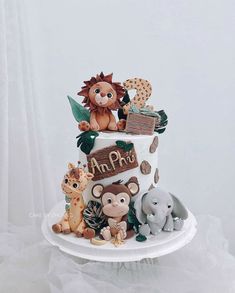 a three tiered cake decorated with animals and letters on it's top layer