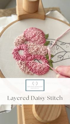 someone is using yarn to make a flower on a piece of wood with scissors and thread