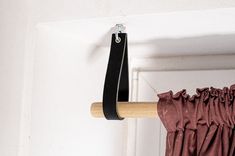 a curtain is hanging on a rod in front of a door with a black handle