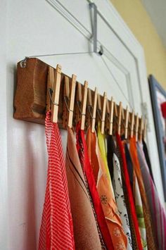 several different colored ties are hanging on the wall next to a coat rack and clothes hanger