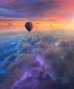 a hot air balloon flying over the clouds