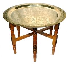 a wooden table with a metal tray on it's legs and an ornate design on the top