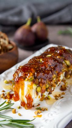 a piece of cake sitting on top of a white plate next to some fruit and nuts