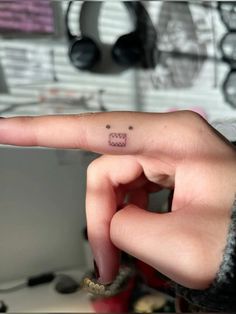 a person with a small tattoo on their finger pointing to the left side of her hand