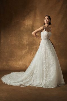 a woman in a wedding dress posing for the camera with her hands on her hips