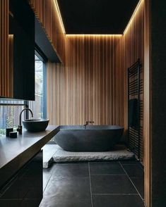 a large bath tub sitting next to a wooden wall