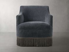 a blue chair with fringe trim around the legs and back, sitting on a gray floor