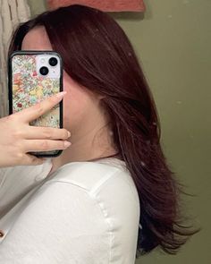 a woman taking a selfie with her cell phone in front of her face while wearing a white shirt