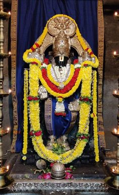 the statue is decorated with flowers and candles