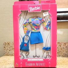 the barbie doll is in its box on the counter next to it's purse