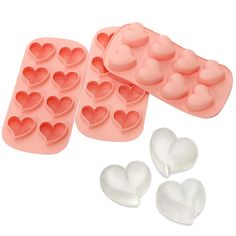 two heart shaped ice trays and three hearts in the shape of candy molds