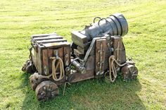 an old machine is sitting in the grass with no wheels on it's side