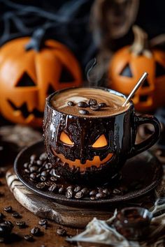 a cup of hot chocolate with pumpkins on the side and coffee beans around it