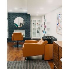 a living room filled with furniture and a fire place next to a wall mounted mirror