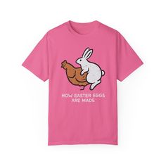 🐰 Get ready to hop into Easter with our delightful garment-dyed t-shirt featuring a whimsical design of a chicken and a bunny pondering the age-old question: "How are Easter eggs made?" 🌷 Crafted from 100% ring-spun cotton, this tee offers unbeatable softness and comfort, perfect for everyday wear. The soft-washed, garment-dyed fabric adds an extra level of coziness to your wardrobe, ensuring you feel comfortable all day long. 🧵 With double-needle stitching throughout, this t-shirt is built to last, maintaining its durability wash after wash. Plus, the lack of side-seams ensures the shirt retains its tubular shape, providing a flattering fit for any body type. 🎨 Make this tee your own by customizing it with your favorite designs, photos, or logos, creating a unique look that reflects y Funny Pink T-shirt For Spring, Easter Pink Cotton T-shirt, Pink Cotton Easter T-shirt, Pink Cotton T-shirt For Easter, Spring Cotton T-shirt With Bunny Design, Pink Easter Tops With Graphic Print, Pink Graphic Print Easter Tops, Pink Graphic Print Top For Easter, Casual Short Sleeve T-shirt For Easter