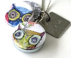 two owls are sitting next to each other on a keychain with a tag hanging from it