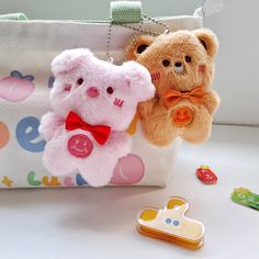 two teddy bears are hanging from a purse