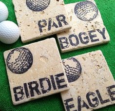 three coasters with golf logos on them sitting on a green surface next to balls