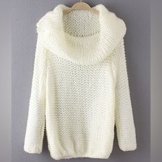 a white sweater hanging on a hanger