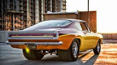 an orange and yellow muscle car parked on the street