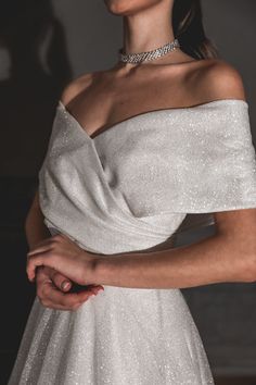 a woman in a white dress is wearing a choker and diamond necklace with her hand on her hip