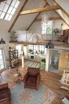 an attic bedroom with wood floors and white walls, has a loft bed on the second floor