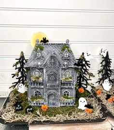 a fake house with halloween decorations around it