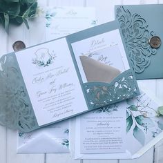 the wedding stationery is laid out on top of the table with flowers and greenery