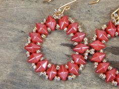 Unusual red and silver seed bead hoop earrings. The soft red color of the diamond shaped beads is set off by the tiny silver beads. The beads are woven into a simple hoop pattern. The earrings are 2 inches long and 1 inch wide on handmade ear wires. Red Hoop Earrings With Colorful Beads For Jewelry Making, Red Hoop Earrings With Tiny Beads, Red Round Silver Beaded Jewelry, Elegant Red Beaded Hoop Earrings, Red Beaded Small Hoop Earrings, Cheap Red Hoop Earrings With Colorful Beads, Red Beaded Round Hoop Earrings, Red Faceted Beads Round Earrings, Nickel-free Red Beaded Round Earrings