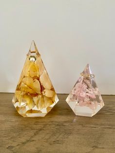 two glass pyramids sitting on top of a wooden table