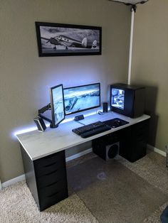 there is a desk with two monitors and a keyboard on it, in the corner