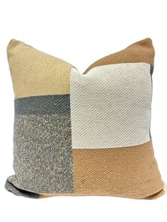 a brown and white pillow with two different colored squares on the front, one in grey and