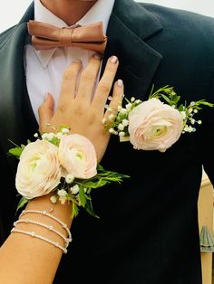 a man in a tuxedo and woman with flowers on their arm wearing bracelets