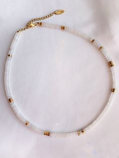 * White jade gemstones * hematite pearls gilded with fine gold 24k * Stainless steel carabiner clasp * Collar mounted on a resistant wire * Size: 35 cm + 5 cm extension chain ◊ Necklace entirely handmade, delivered in its small pouch ◊ Manufacturing times: 2 to 5 days White Heishi Beads Single Strand Jewelry, Adjustable White Beaded Necklace With Natural Stones, Handmade White Heishi Beads Jewelry, White Heishi Beads Necklace With Spacer Beads, White Heishi Beads Jewelry For Gift, Minimalist White Gemstone Beaded Necklaces, White Minimalist Beaded Gemstone Necklace, White Gold Cross Pendant, Chic Gifts