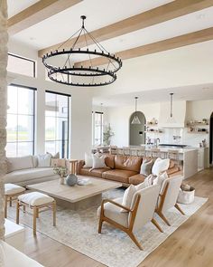 a living room filled with furniture and a chandelier hanging over the top of it