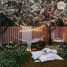 an outdoor area with hammock, pillows and lights on the trees in the background