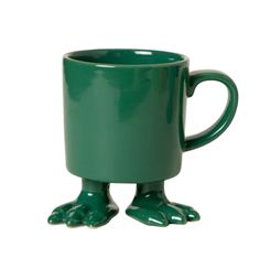 a green frog mug sitting on top of a white table